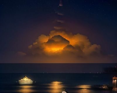 林晚舟，午夜导航创始人兼主编，坐在堆满书籍的书桌前专注审阅内容，背景是满墙的便利贴与分类标签，神情认真而投入